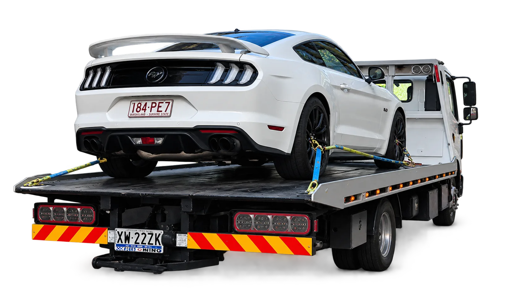 White Ford Mustang strapped onto a flatbed tow truck